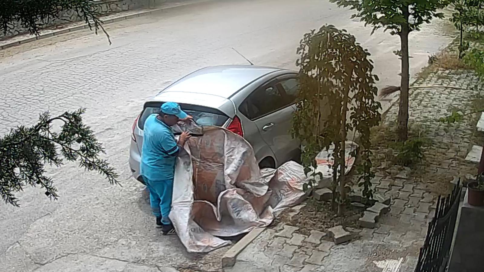 Temizlik personelinden park halindeki aracın zarar görmemesi için brandalı önlem